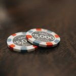 two poker chips sitting on top of a wooden table