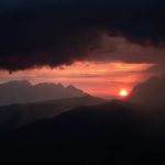 The sun is setting over a mountain range