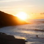Sunset on the beach with a surfer.