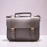 black leather handbag on white table